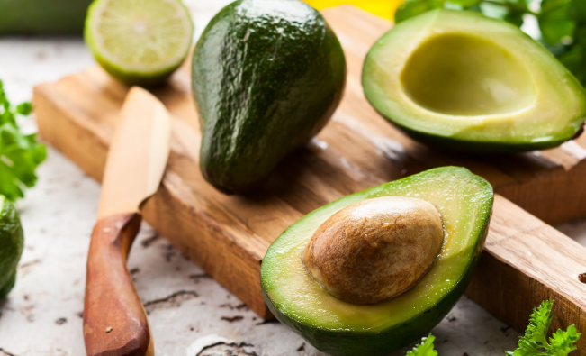 Fresh avocado cut in half on a wooden board